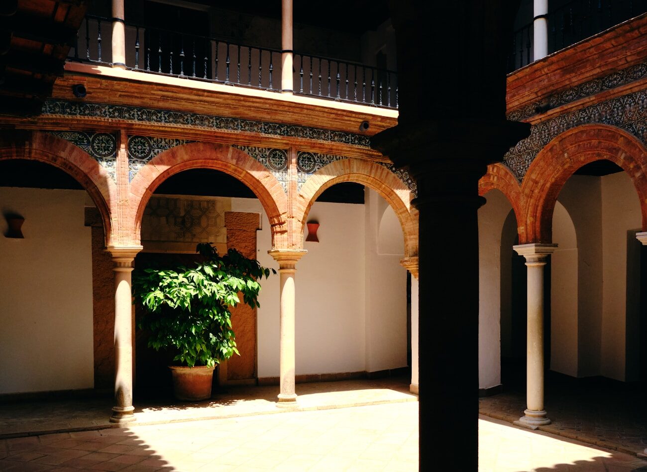 An arched courtyard lit warmly at night
