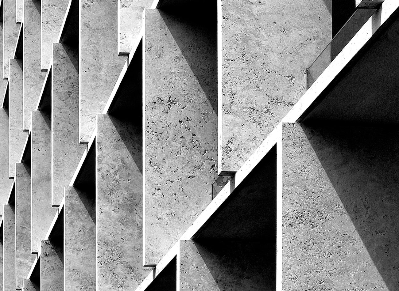 An angular concrete facade with deep shadow