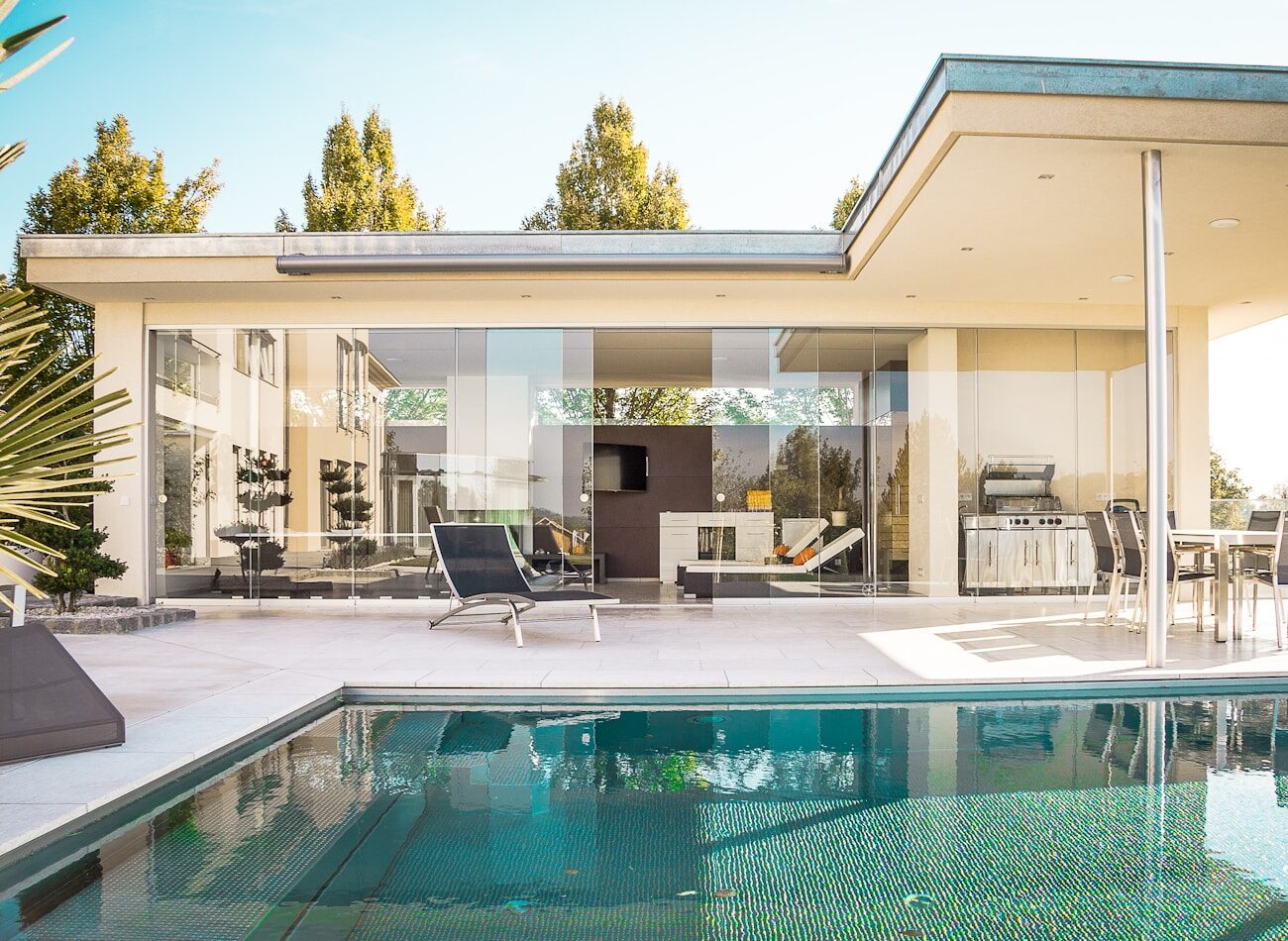A pool house glowing at dusk above the water