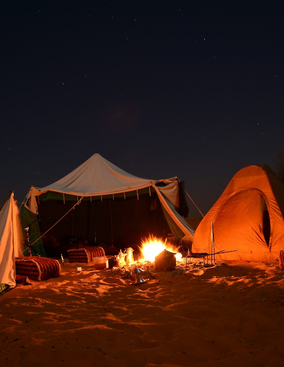 A single lamp-lit tent glowing in the desert at night