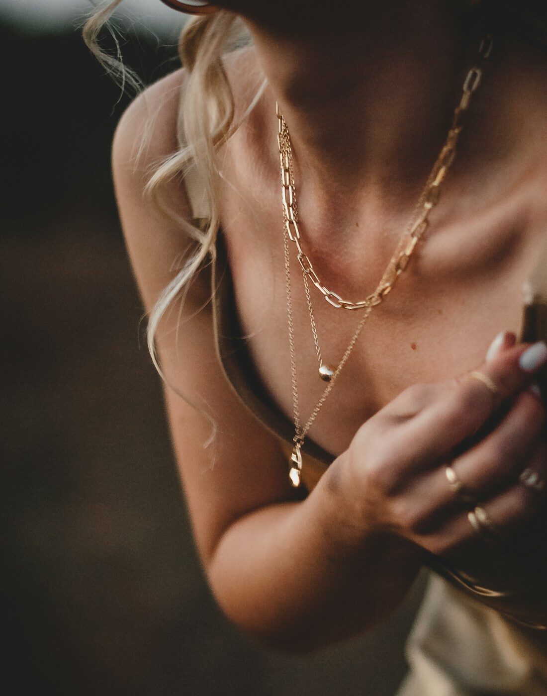 Fine gold necklaces layered at the collarbone