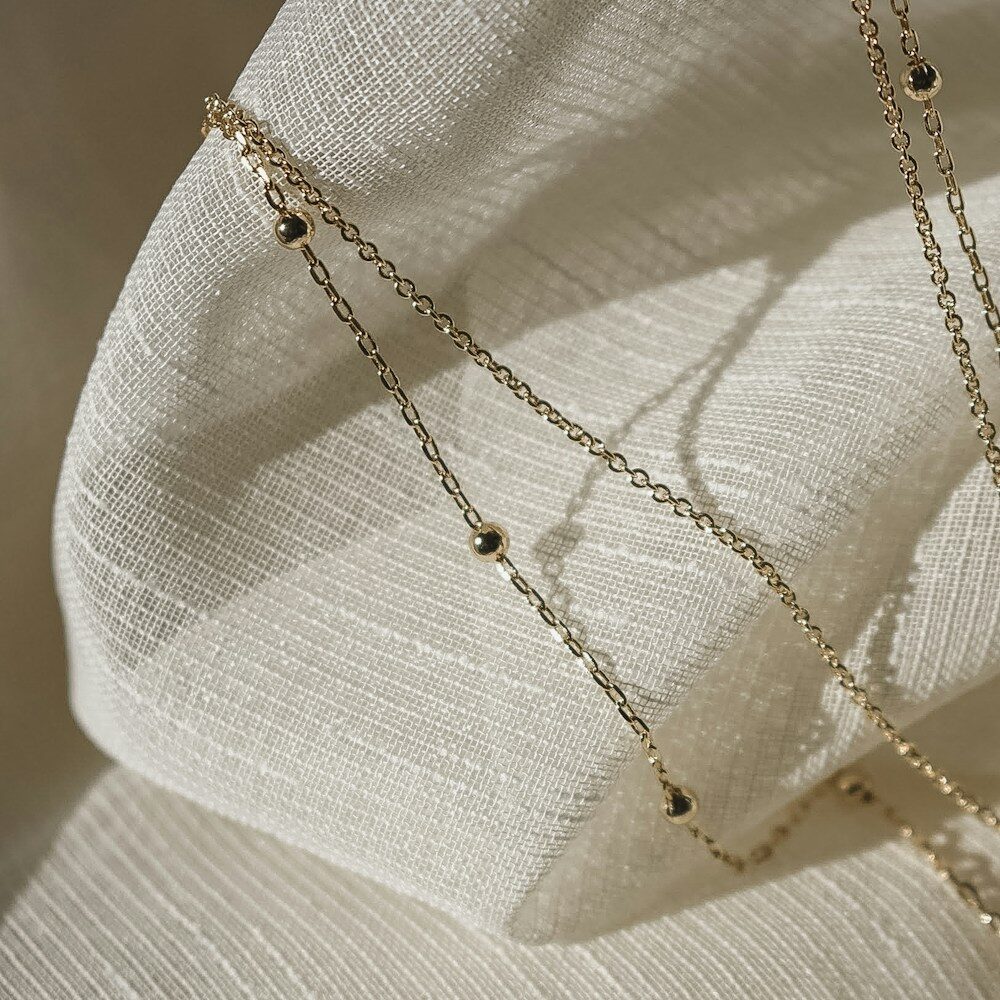 A fine gold chain on cream cloth